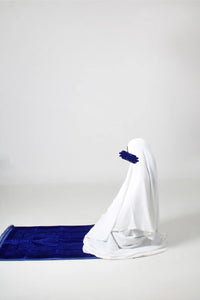 Muslimsk-kvinne-som-ber-på-blått-bønneteppe-qamar.no